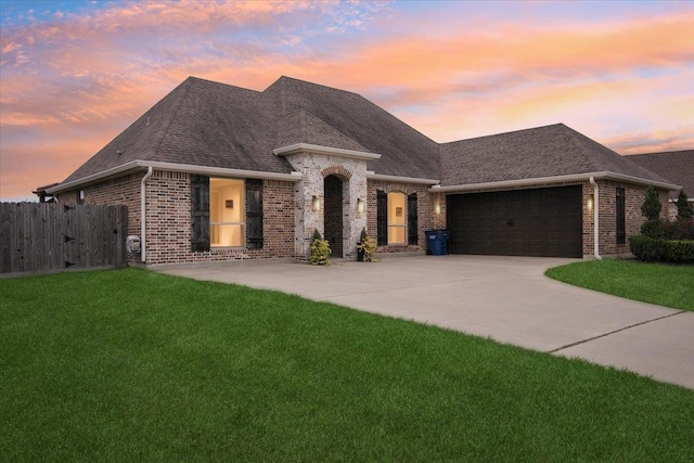 french country home featuring a yard and a garage