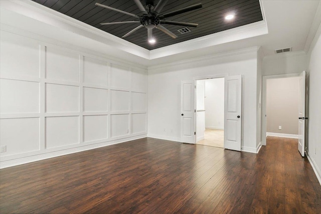 spare room with ceiling fan, dark hardwood / wood-style floors, crown molding, and a tray ceiling