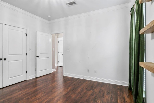 unfurnished bedroom with crown molding and dark wood-type flooring