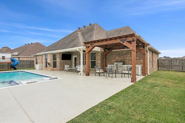 view of swimming pool with an outdoor kitchen, a pergola, and a lawn