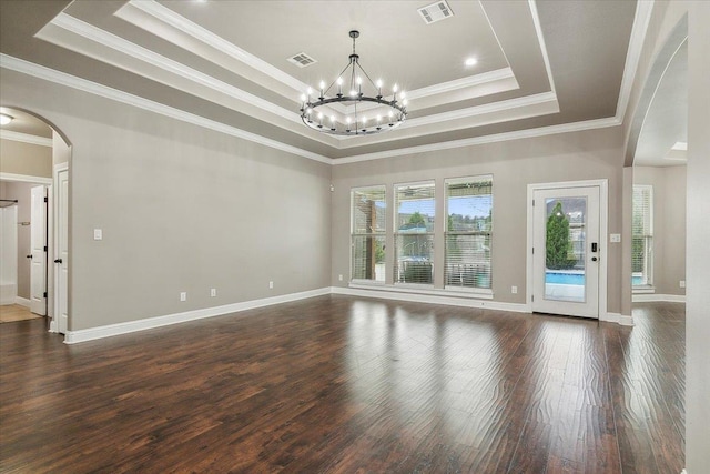 unfurnished room with a chandelier, dark hardwood / wood-style floors, ornamental molding, and a tray ceiling