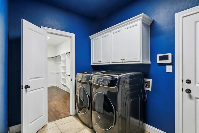 laundry area featuring cabinets, washing machine and dryer, and light tile patterned floors