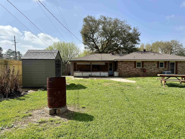 view of yard featuring a storage unit, an outdoor structure, and fence