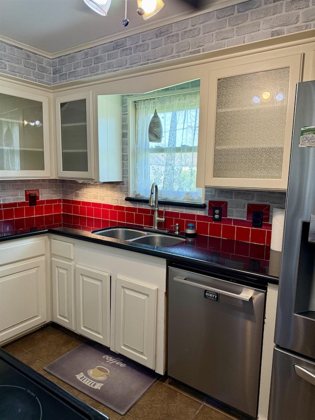 kitchen featuring a sink, dark countertops, decorative backsplash, and stainless steel appliances