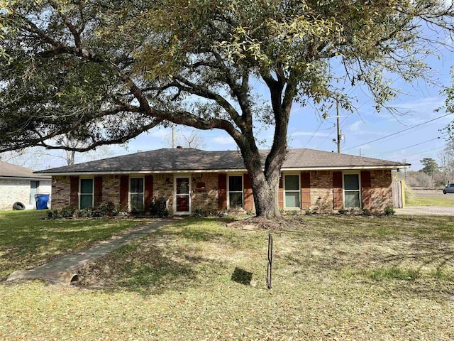 ranch-style home featuring a front lawn and brick siding