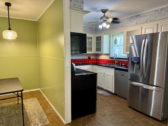 kitchen with dark countertops, ceiling fan, ornamental molding, stainless steel appliances, and a sink