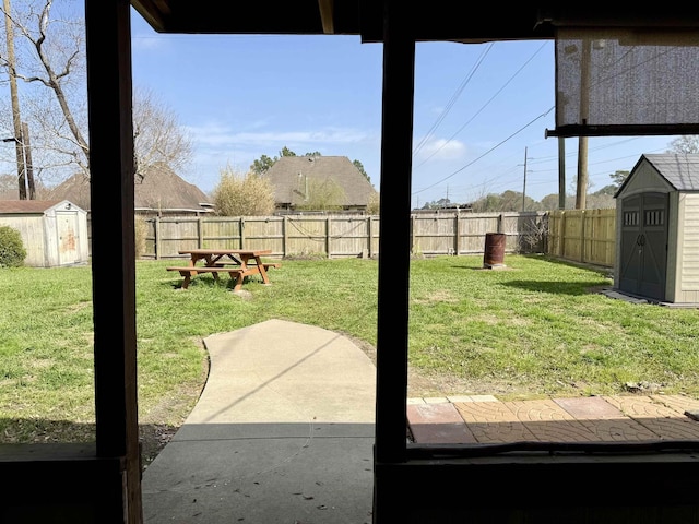 view of yard featuring an outbuilding, a fenced backyard, and a shed