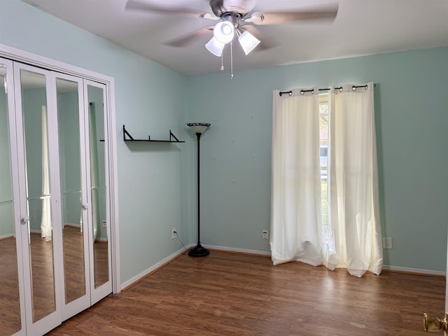 unfurnished bedroom with ceiling fan, baseboards, and wood finished floors