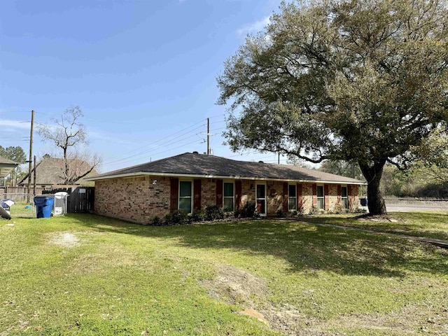 single story home with brick siding, a front yard, and fence