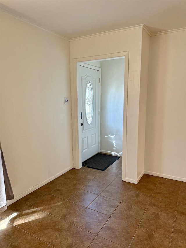 foyer entrance featuring crown molding, dark tile patterned flooring, and baseboards