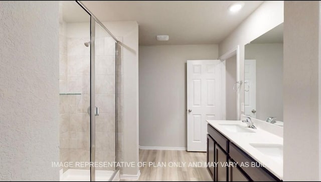 1690 Haidlyns Way, Sour Lake, TX 77659 - bathroom with double vanity, a shower stall, wood finished floors, and a textured wall