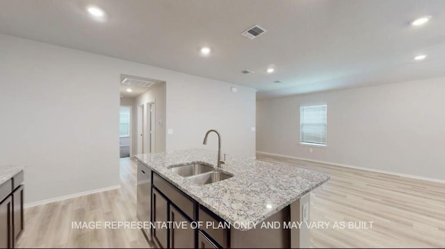 1690 Haidlyns Way, Sour Lake, TX 77659 - kitchen with a sink, light wood-style floors, light stone countertops, a kitchen island with sink, and open floor plan