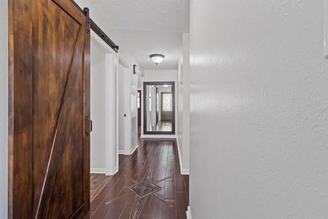 hall featuring a textured ceiling and a barn door