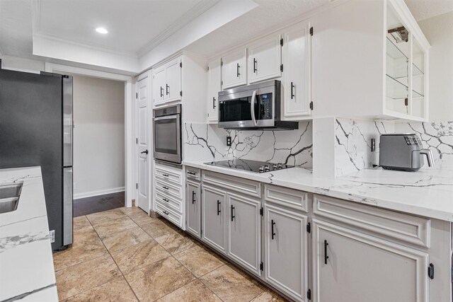 kitchen featuring decorative backsplash, stainless steel appliances, a raised ceiling, and white cabinets