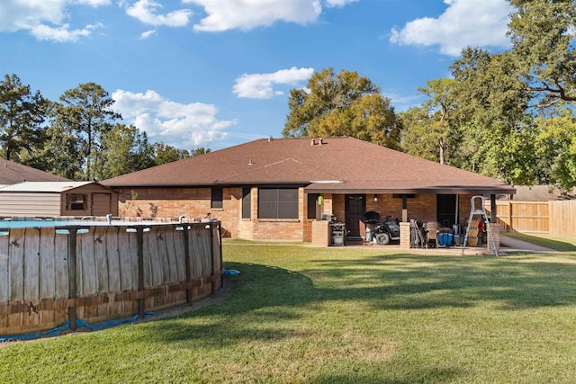 back of property featuring a fenced in pool and a yard