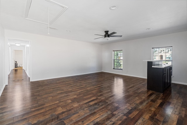 unfurnished living room with ceiling fan and dark wood-type flooring