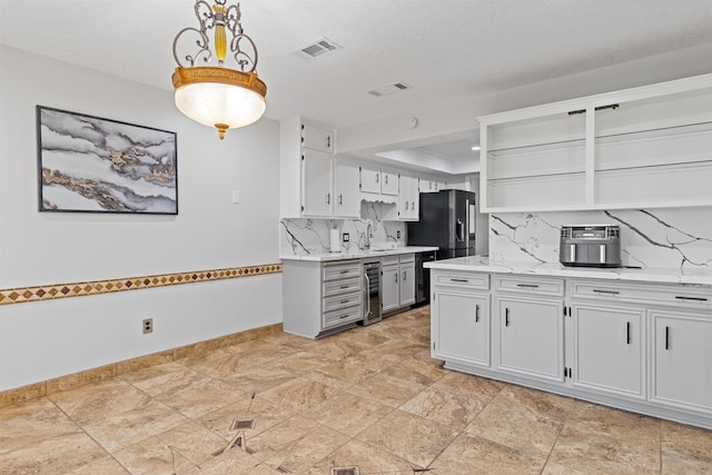 kitchen with white cabinets, hanging light fixtures, wine cooler, and tasteful backsplash