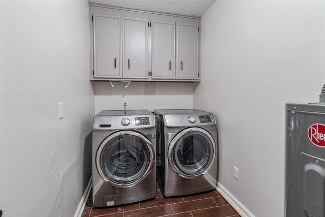 laundry room with cabinets, a textured ceiling, washing machine and dryer, and electric water heater