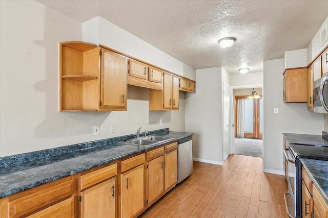 kitchen featuring sink, stainless steel appliances, light hardwood / wood-style floors, and a textured ceiling