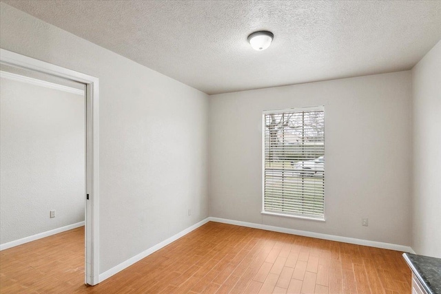 empty room with wood-type flooring and a textured ceiling