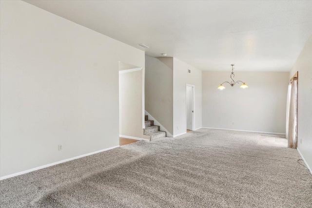 carpeted empty room with a notable chandelier