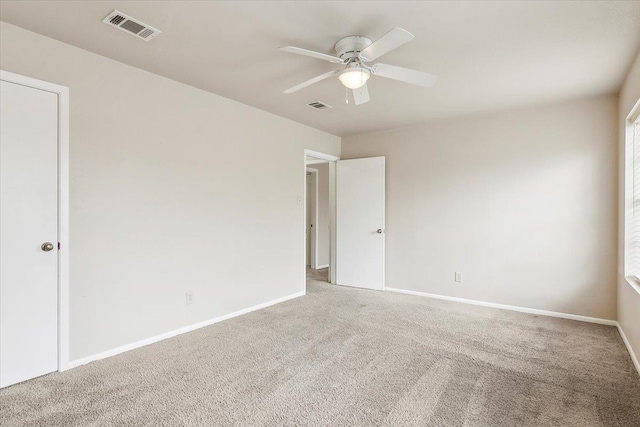 spare room featuring ceiling fan and carpet