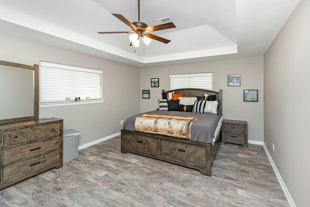 bedroom with ceiling fan and a raised ceiling