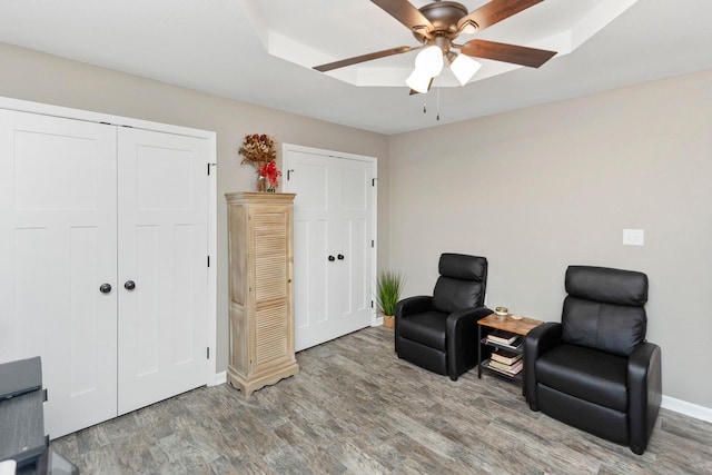 sitting room with wood-type flooring and ceiling fan