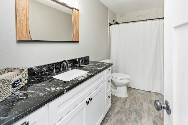 bathroom with a shower with shower curtain, hardwood / wood-style floors, vanity, and toilet