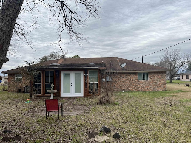 rear view of property with a lawn, a patio area, and french doors