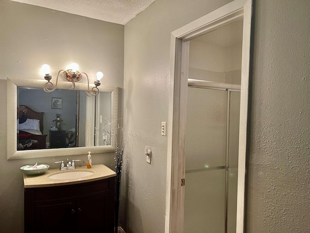 bathroom with vanity, a textured ceiling, and walk in shower