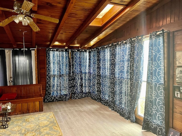 interior space featuring ceiling fan, wooden ceiling, lofted ceiling with beams, wood-type flooring, and wooden walls