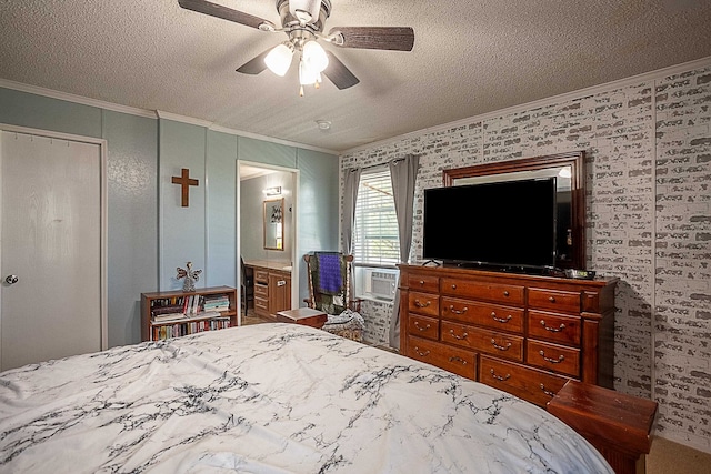 bedroom featuring ceiling fan, ensuite bathroom, a textured ceiling, and ornamental molding