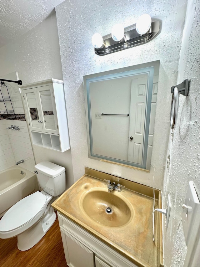 full bathroom with vanity, toilet, wood-type flooring, and tiled shower / bath combo