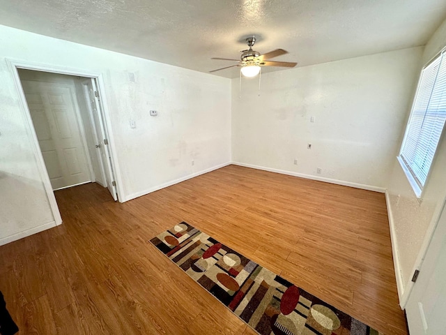 spare room with hardwood / wood-style floors, a textured ceiling, and ceiling fan