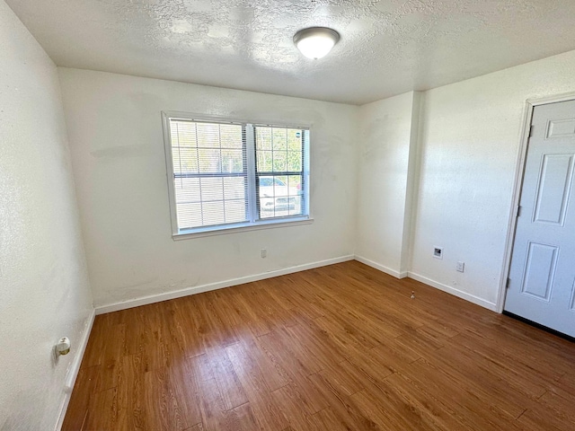 empty room featuring hardwood / wood-style floors and a textured ceiling