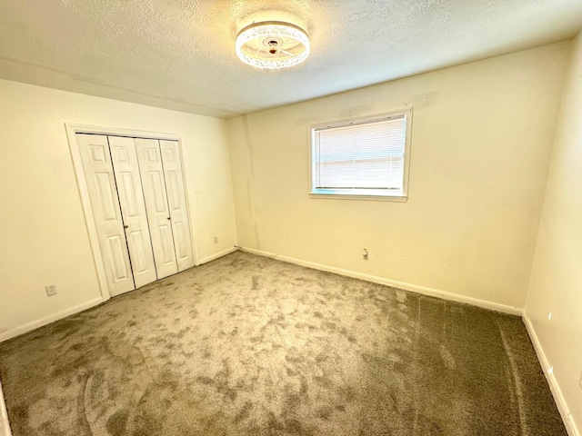 unfurnished bedroom featuring a closet, carpet, and a textured ceiling