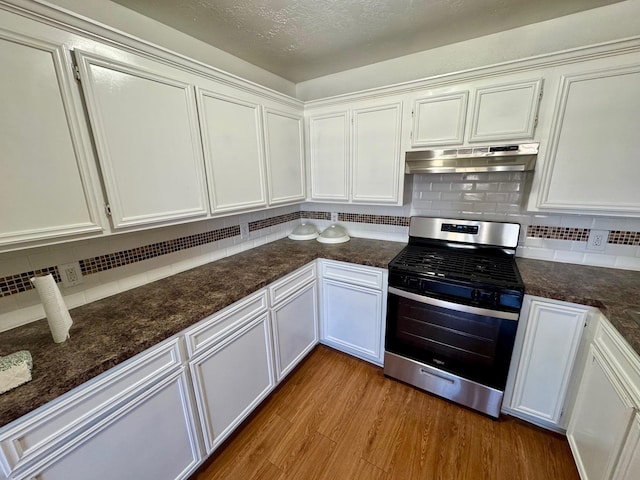 kitchen featuring backsplash, white cabinets, a textured ceiling, light hardwood / wood-style floors, and stainless steel range oven