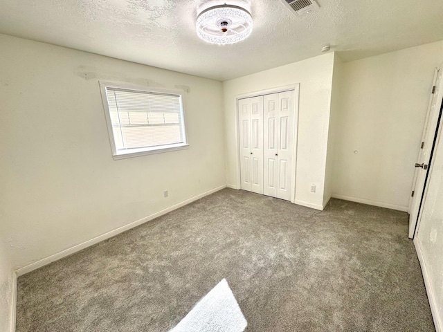 unfurnished bedroom with a closet, carpet floors, and a textured ceiling