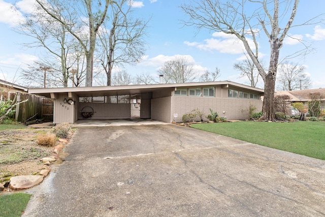 ranch-style home featuring a carport and a front lawn