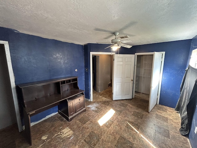 unfurnished bedroom featuring ceiling fan, a textured ceiling, and a closet