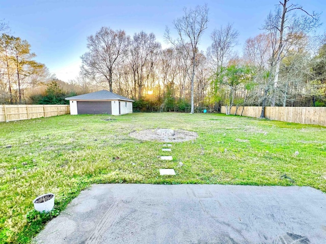 view of yard featuring a detached garage, an outdoor structure, and fence