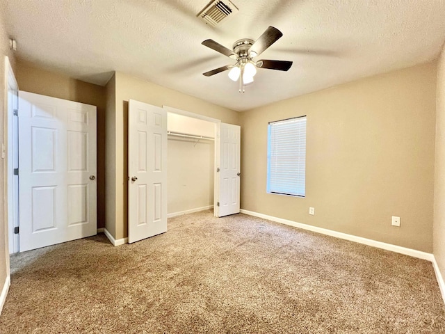 unfurnished bedroom with visible vents, light carpet, a textured ceiling, and baseboards