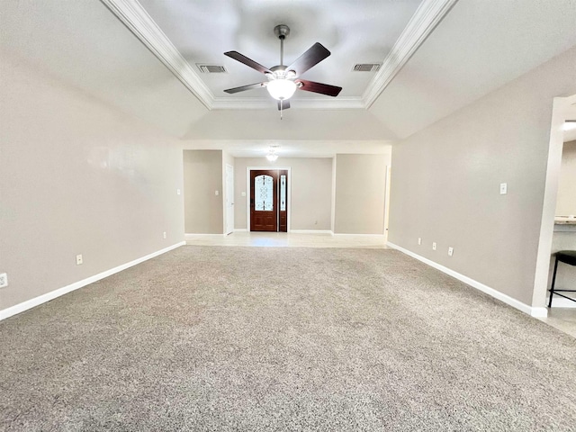 unfurnished living room with visible vents, baseboards, a tray ceiling, ornamental molding, and carpet floors