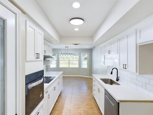 kitchen featuring sink, black appliances, light tile patterned floors, white cabinetry, and hanging light fixtures