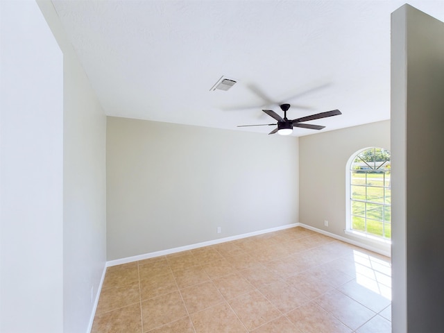 tiled spare room with ceiling fan