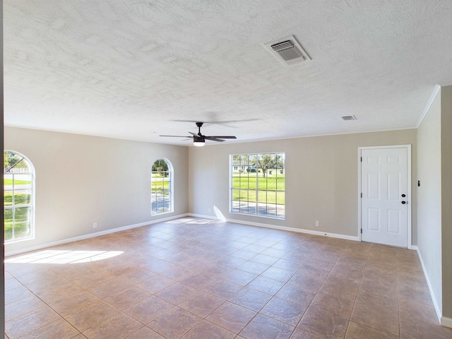 spare room with a textured ceiling, ceiling fan, and light tile patterned flooring