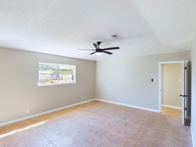 unfurnished room featuring ceiling fan, light tile patterned floors, and a textured ceiling