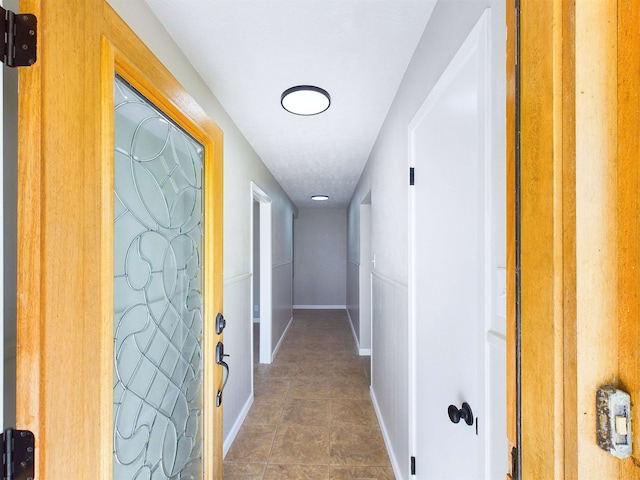 hallway featuring dark tile patterned floors