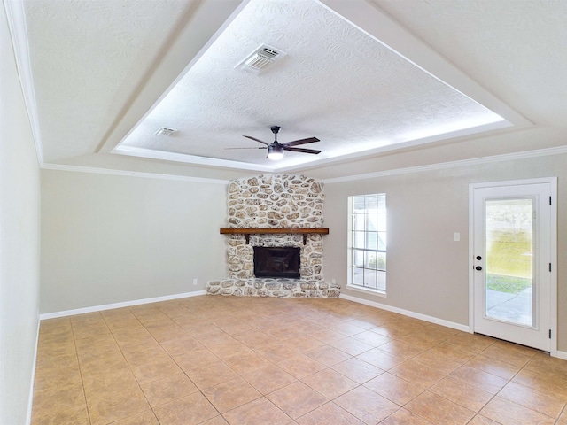 unfurnished living room with ceiling fan, a healthy amount of sunlight, a stone fireplace, and light tile patterned flooring